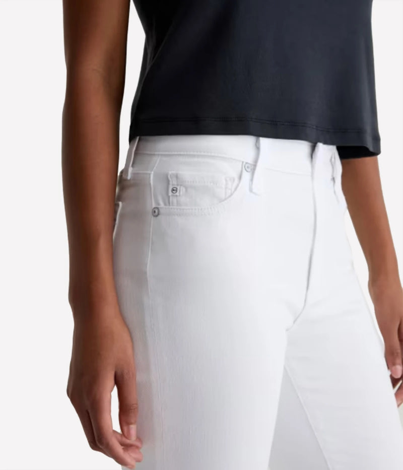 Person wearing a black top and white jeans on a plain background