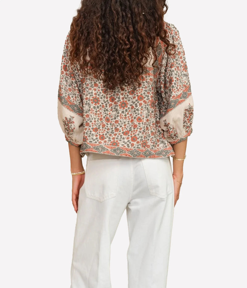 Model wearing the M.A.B.E Della Print Jacket in Rust Khaki with white trousers – back view