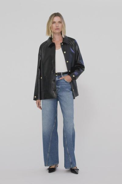 A video of a model wearing the Anine Bing Luca Jacket in Black Recycled leather showcasing the front and back of the jacket paired back with blue denim jeans and a slingback kitten heel.