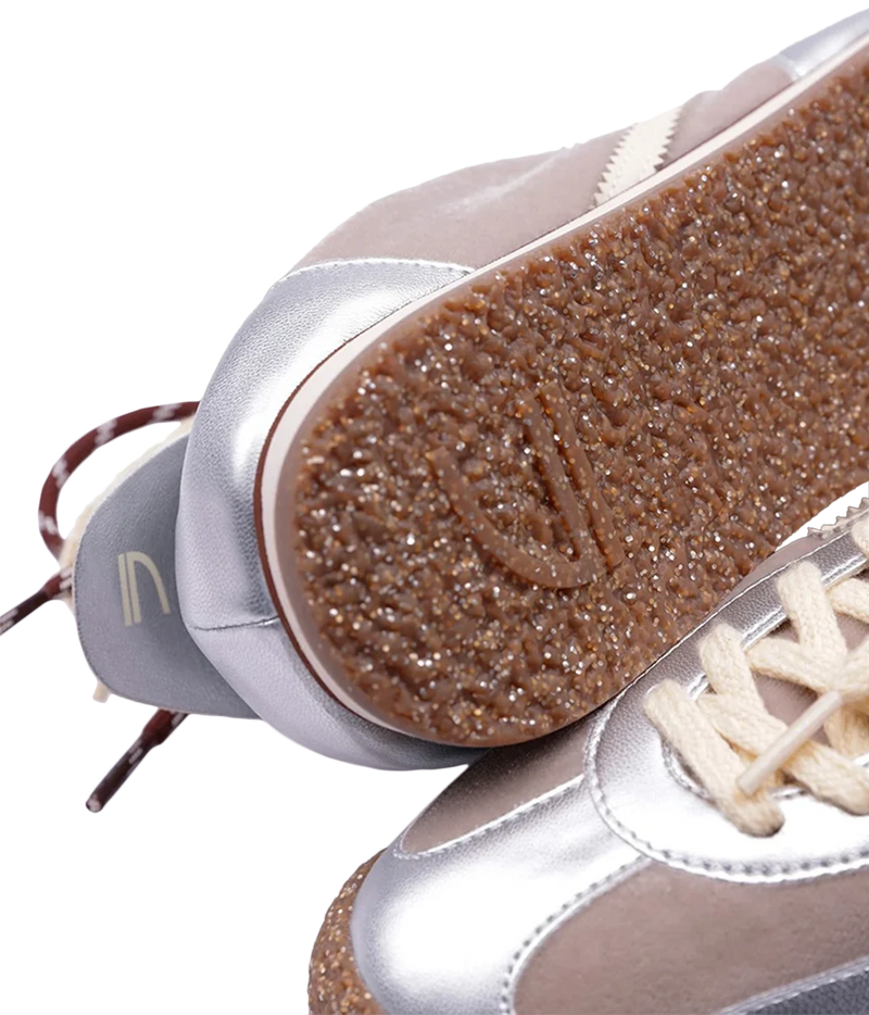 Close-up of a pair of low-top sneakers showing the textured brown glittery outsole and metallic silver and taupe panels, Puraai 6.02 Panther Sneaker in Radio