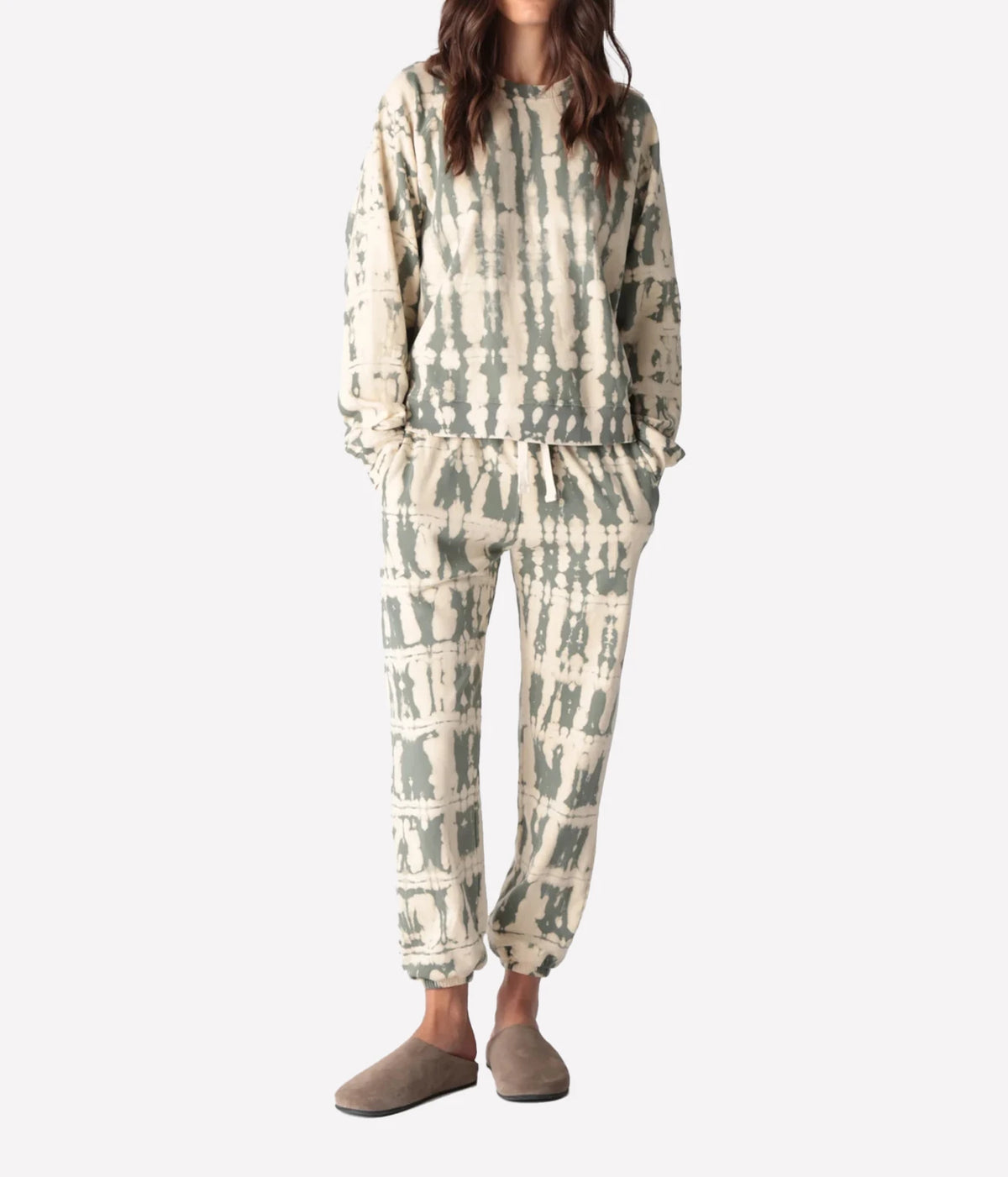 Full-length front view of a model wearing the Electric Rose Ronan Horizon Sweatshirt in Moss Ivory with matching tie-dye joggers, hands in pockets and taupe suede clogs