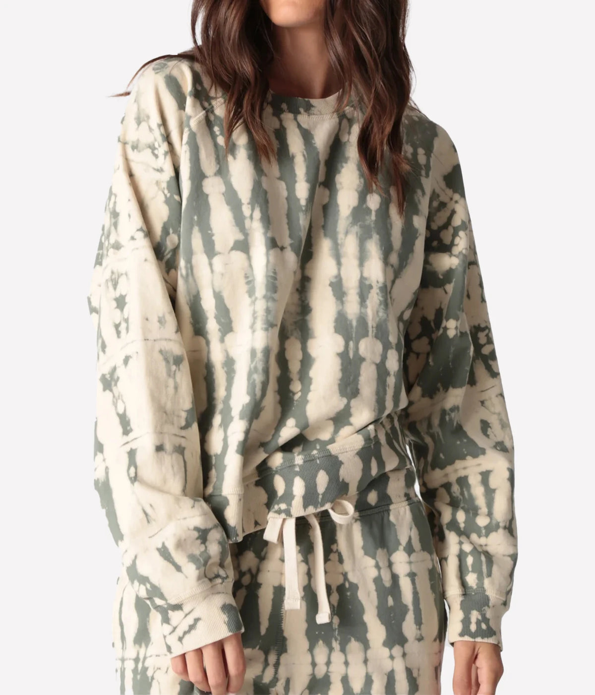 Close-up front view of a model wearing the Electric Rose Ronan Horizon Sweatshirt in Moss Ivory, showing the moss and ivory tie-dye, crew neck and dropped shoulders, with matching tie-dye drawstring joggers