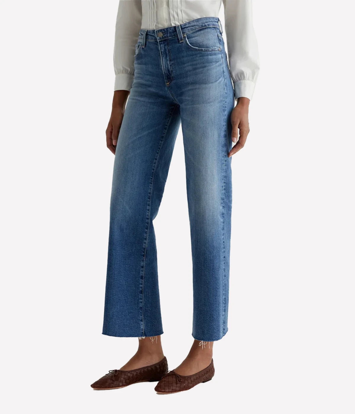 Blue jeans worn by a person on a white background