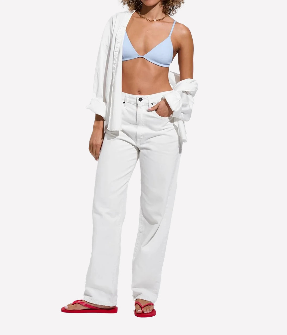 A model wearing white wide-leg jeans, a light blue bikini top, an open white shirt, Sandy Top In Blue Skies