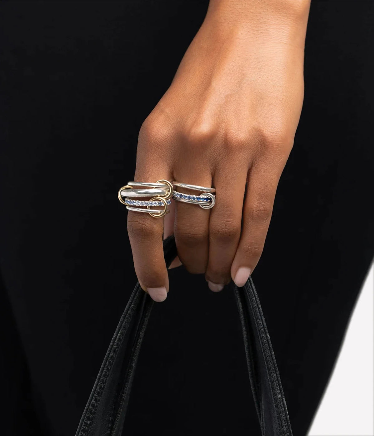 Model wearing the Spinelli Kilcollin Petunia SS Ring on her hand with a black top, holding the handles of a black bag