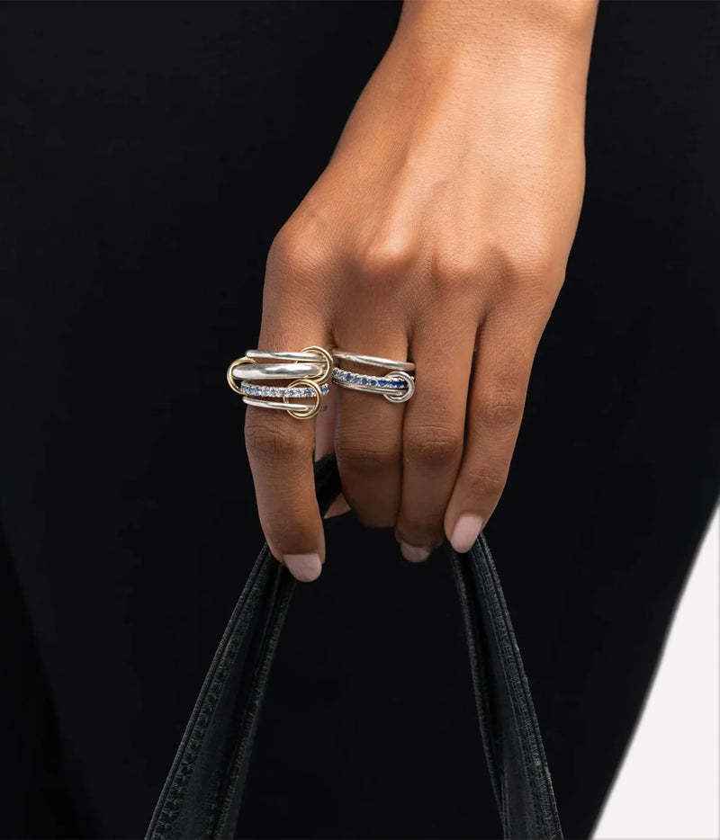Model wearing the Spinelli Kilcollin Petunia SS Ring on her hand with a black top, holding the handles of a black bag