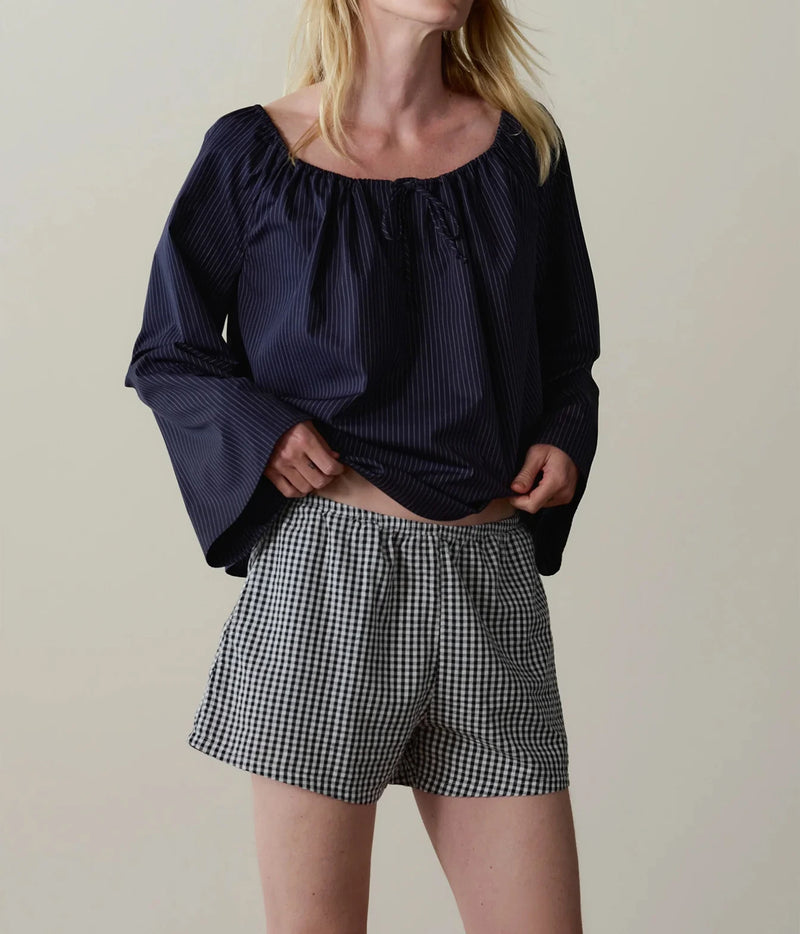 Model wearing navy gingham check shorts with a navy long-sleeve top, front view showing the relaxed fit.