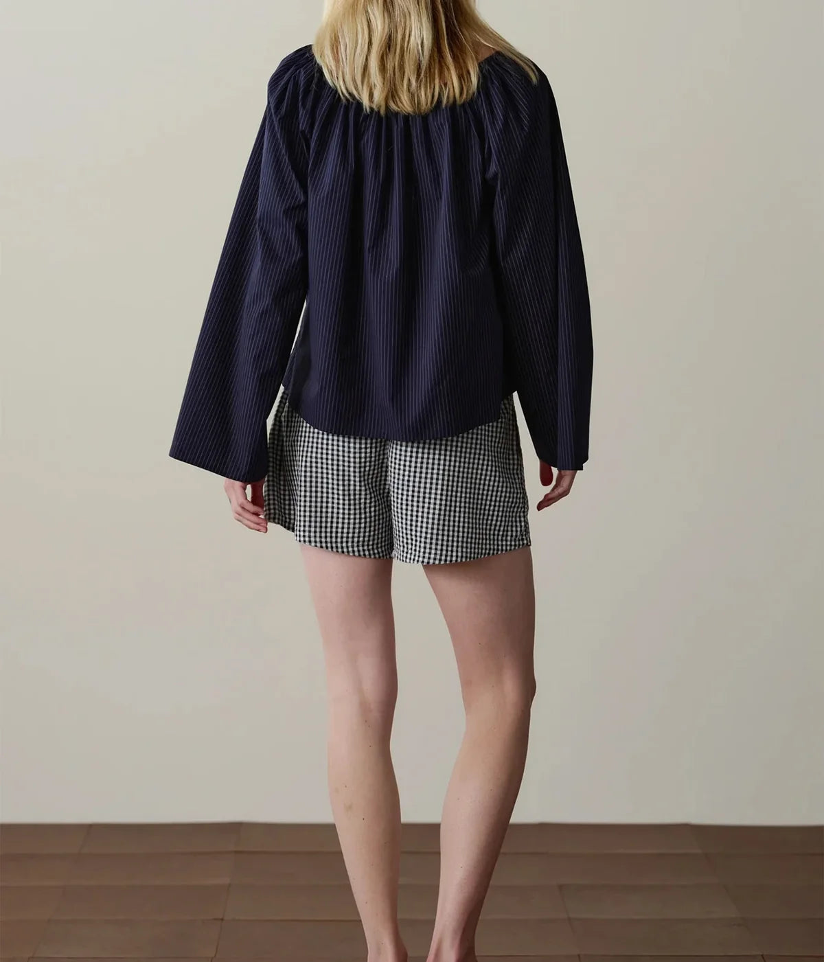 DONNI. The Cotton Gingham Tap Short in JET - model wearing shorts and navy top shown from the back