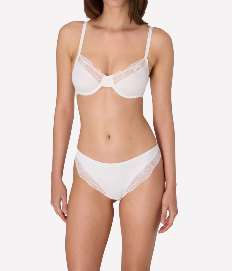 A model wearing a white two-piece lingerie set with lace trim, featuring a sheer underwire bra and matching high-cut briefs, anemone underwire bra in ivory