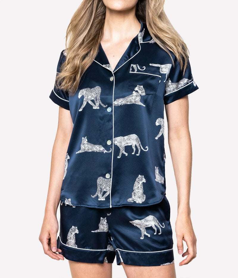 Front view of a model wearing the Petite Plume Mulberry Silk Short Pyjama Set in Panthère de Nuit with the short sleeve shirt buttoned and the matching shorts