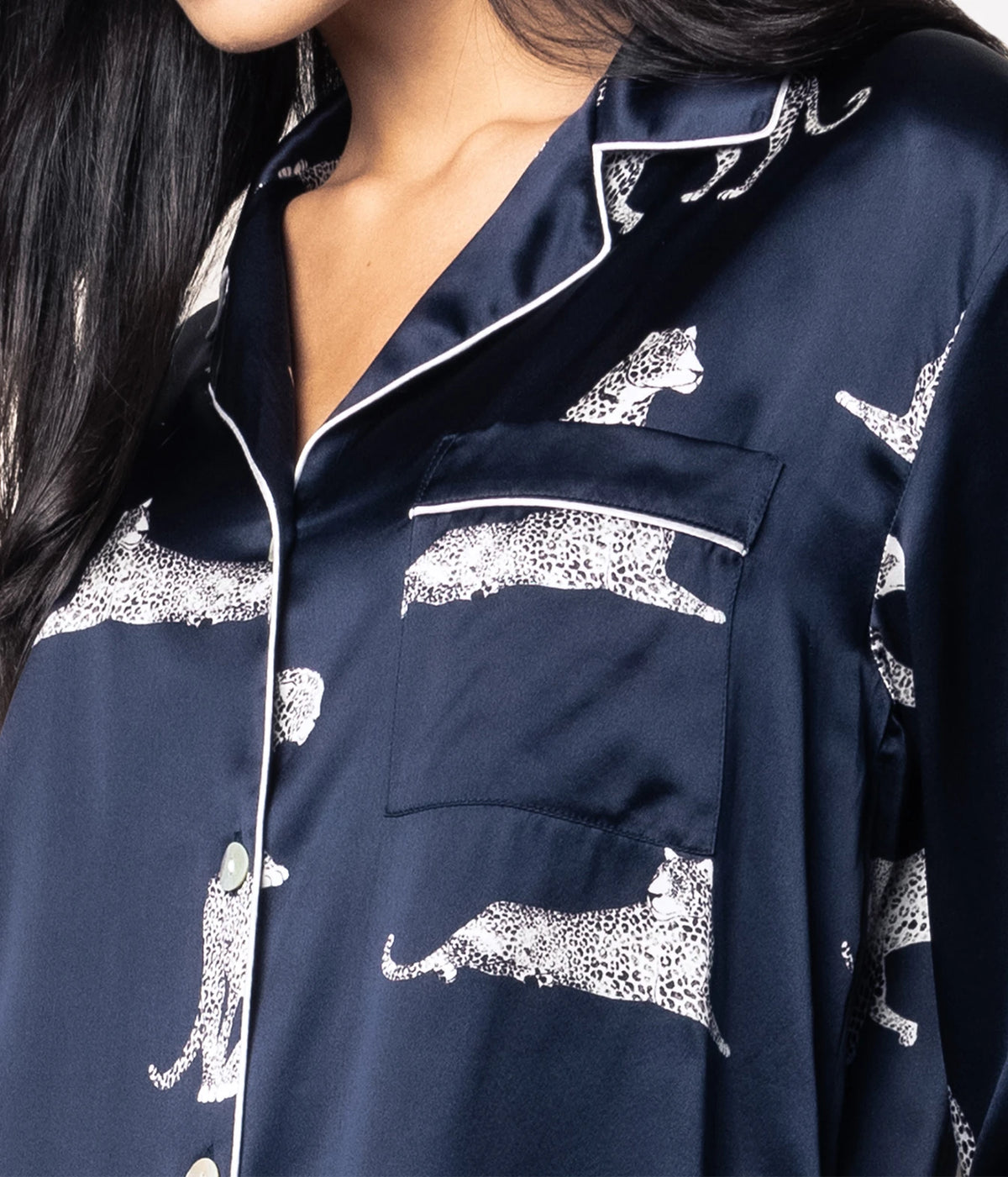 Close-up of a model wearing the Petite Plume Mulberry Silk Long Pyjama Set in Panthère de Nuit, showing the open collar and the panther print across the chest and sleeve