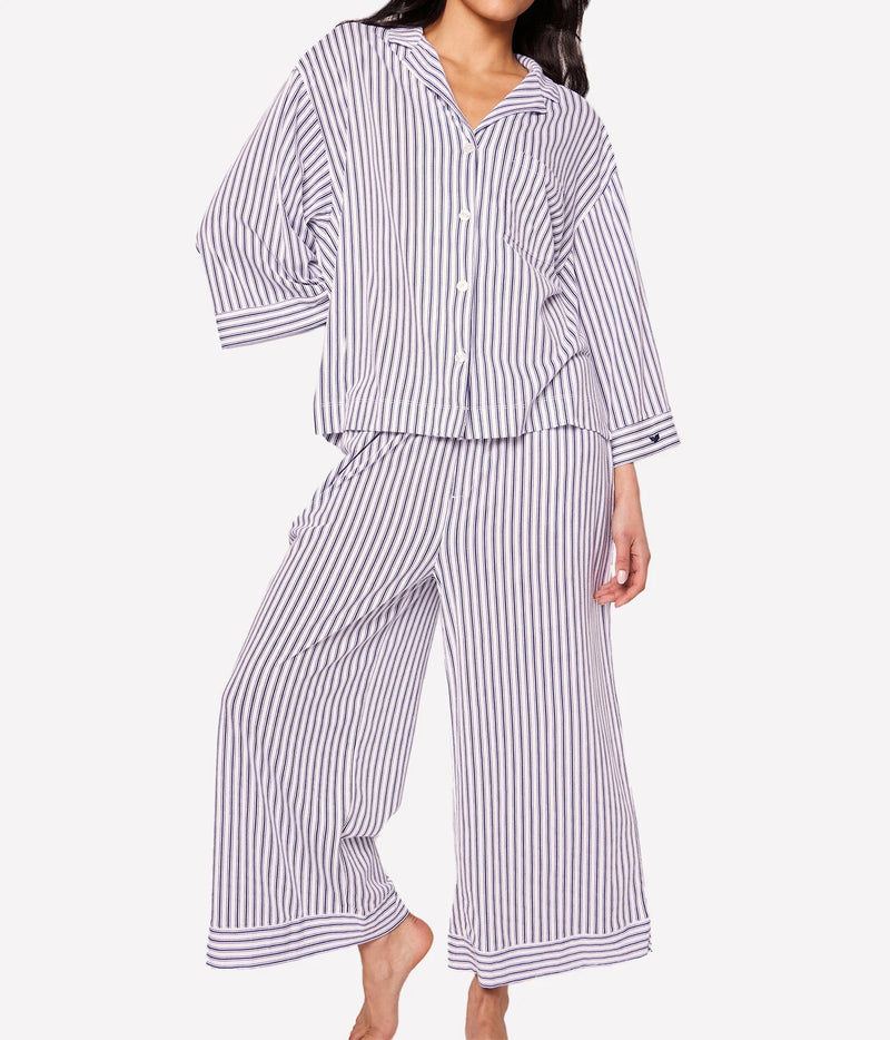 Front view of a model wearing the Petite Plume Olivia Pima Long Pyjama Set in Navy with the shirt buttoned over the wide leg pants
