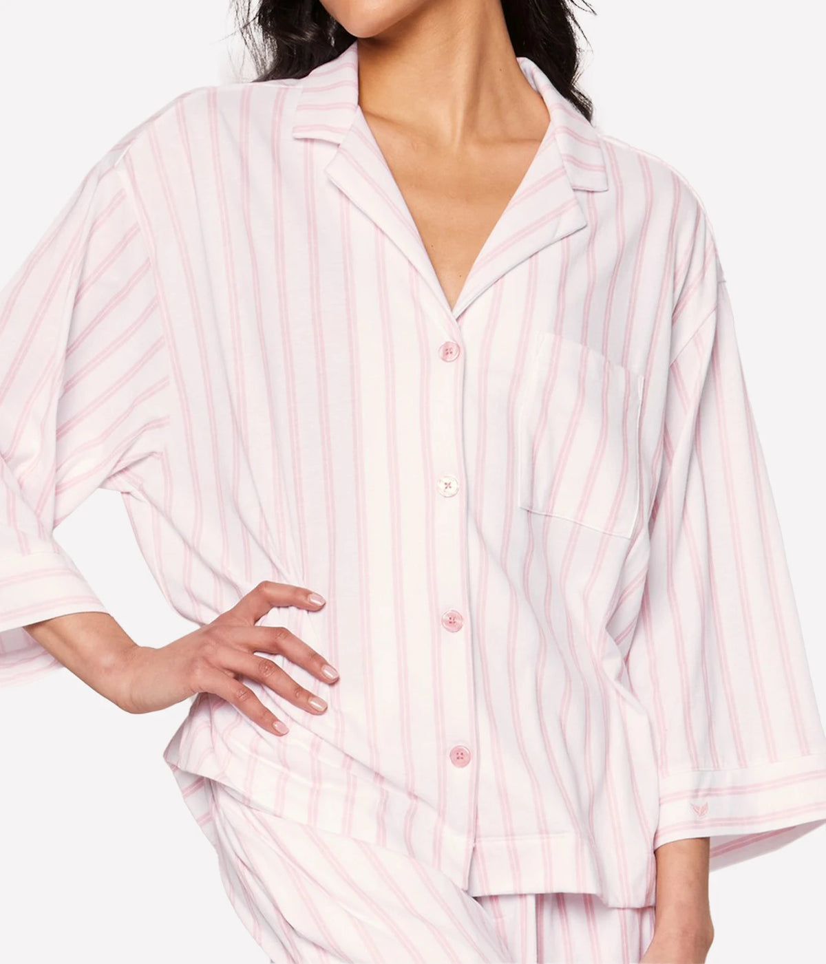 Model wearing the Petite Plume Olivia Pima Long Pyjama Set in Pink Stripe with the shirt buttoned and one hand on her hip, showing the relaxed fit and three-quarter sleeves