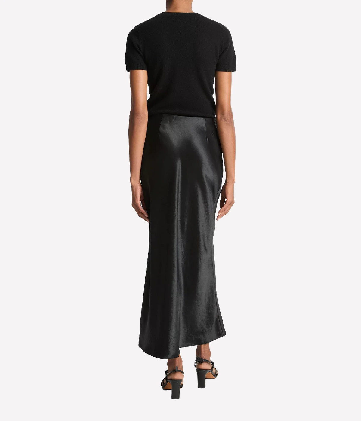 Woman wearing a black satin slip skirt, back view