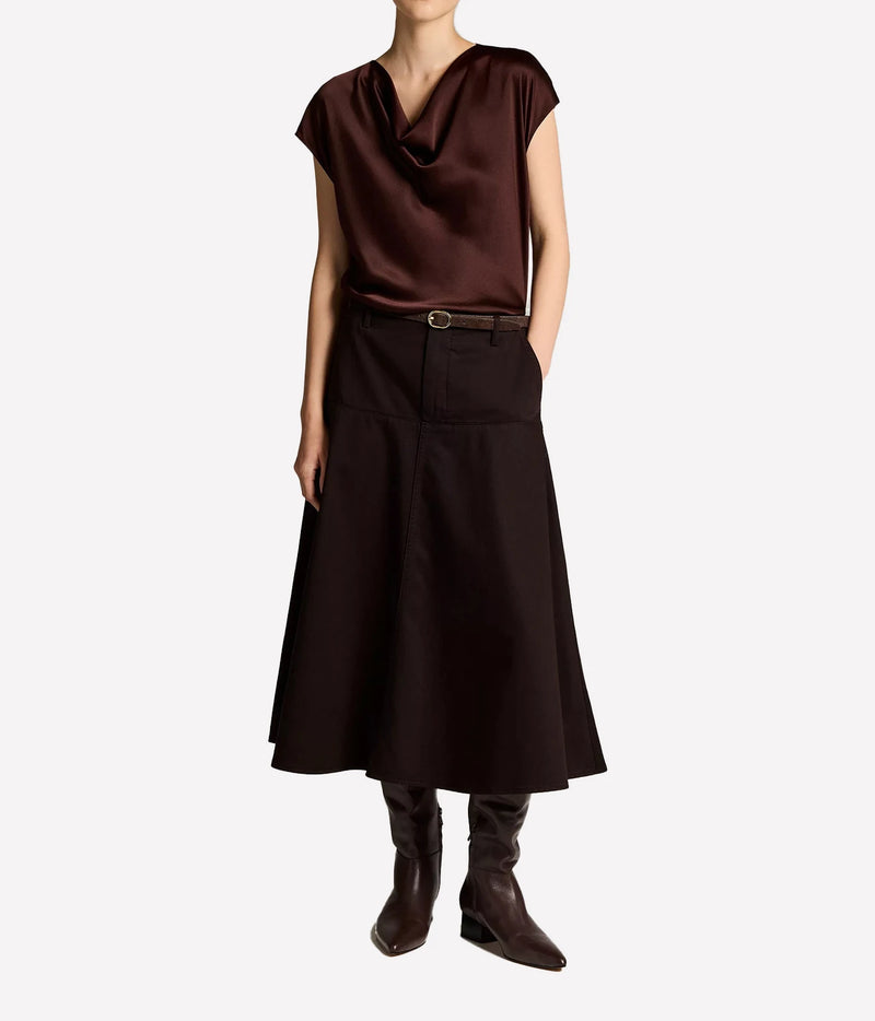 Woman wearing a dark cherrywood cowl neck blouse with matching skirt