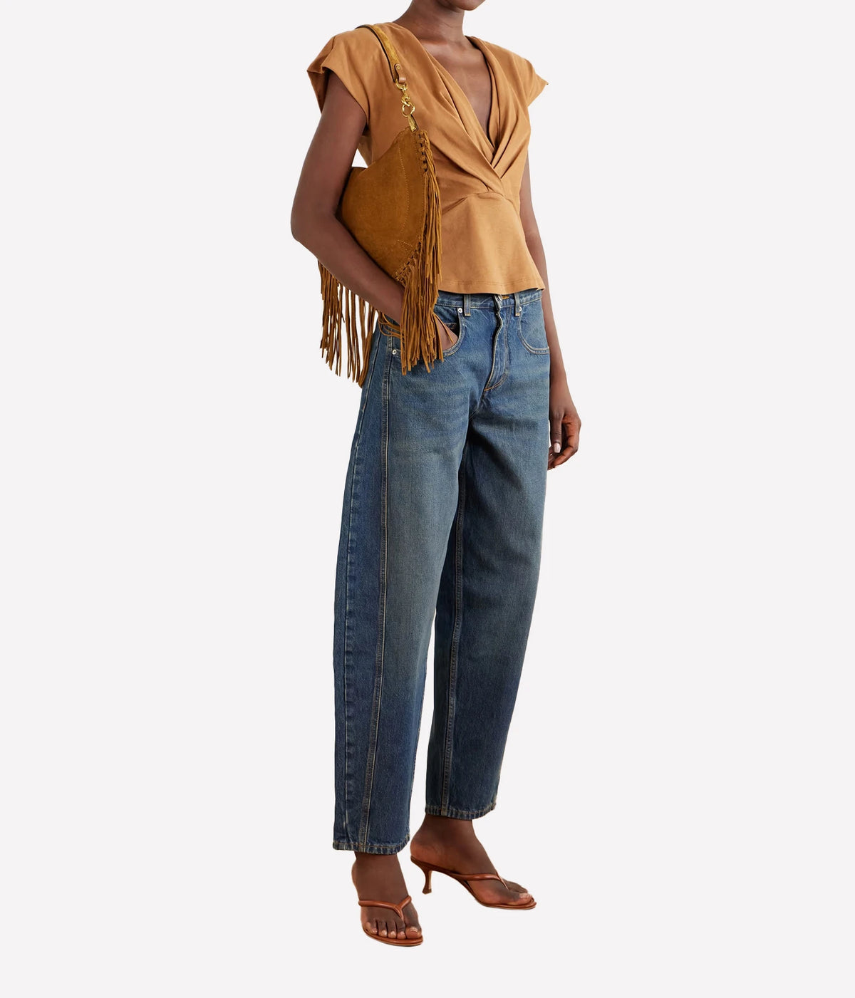 Model wearing Isabel Marant Oskan Soft Zip suede tassel bag in Cognac over the shoulder