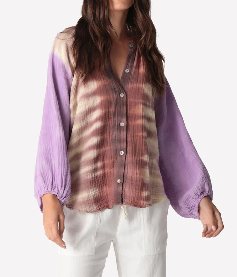 Front view of a model wearing the Electric Rose Winnie Fade Shirt in Lavender Sepia buttoned, showing the sepia tie-dye body, lavender balloon sleeves, band collar and buttons, with white trousers