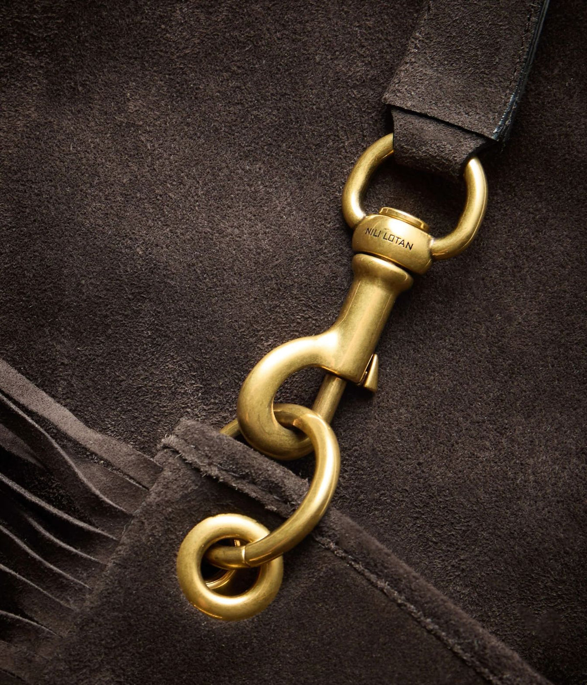 Close-up of a dark brown suede strap with a polished brass swivel clasp and ring hardware, showing the brand name Equestrian engraved on the metal.