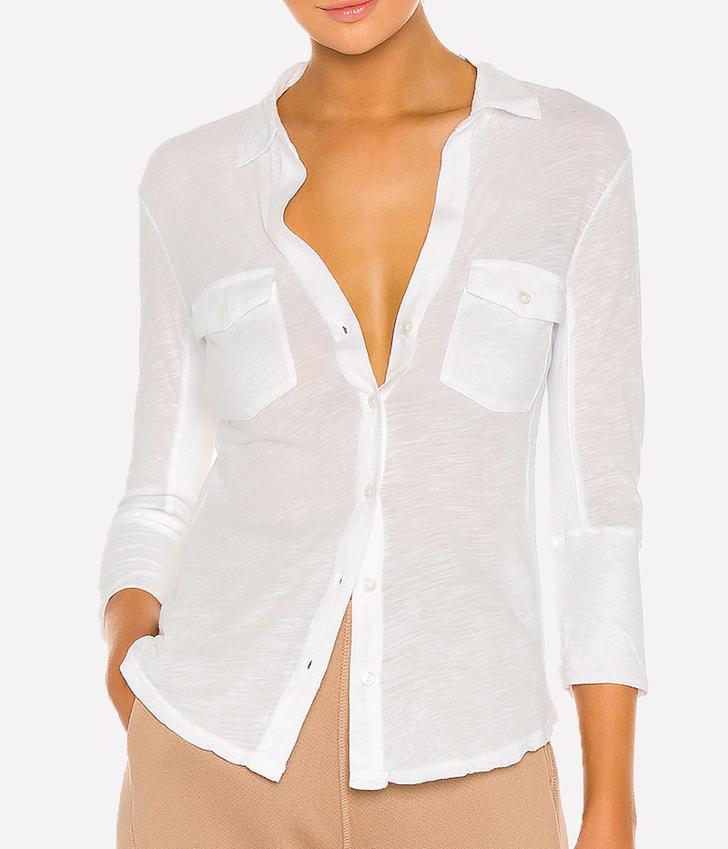 James Perse lightweight slub Supima cotton shirt in white with a slim silhouette, cropped sleeves, and V-neckline, styled with high-rise denim.