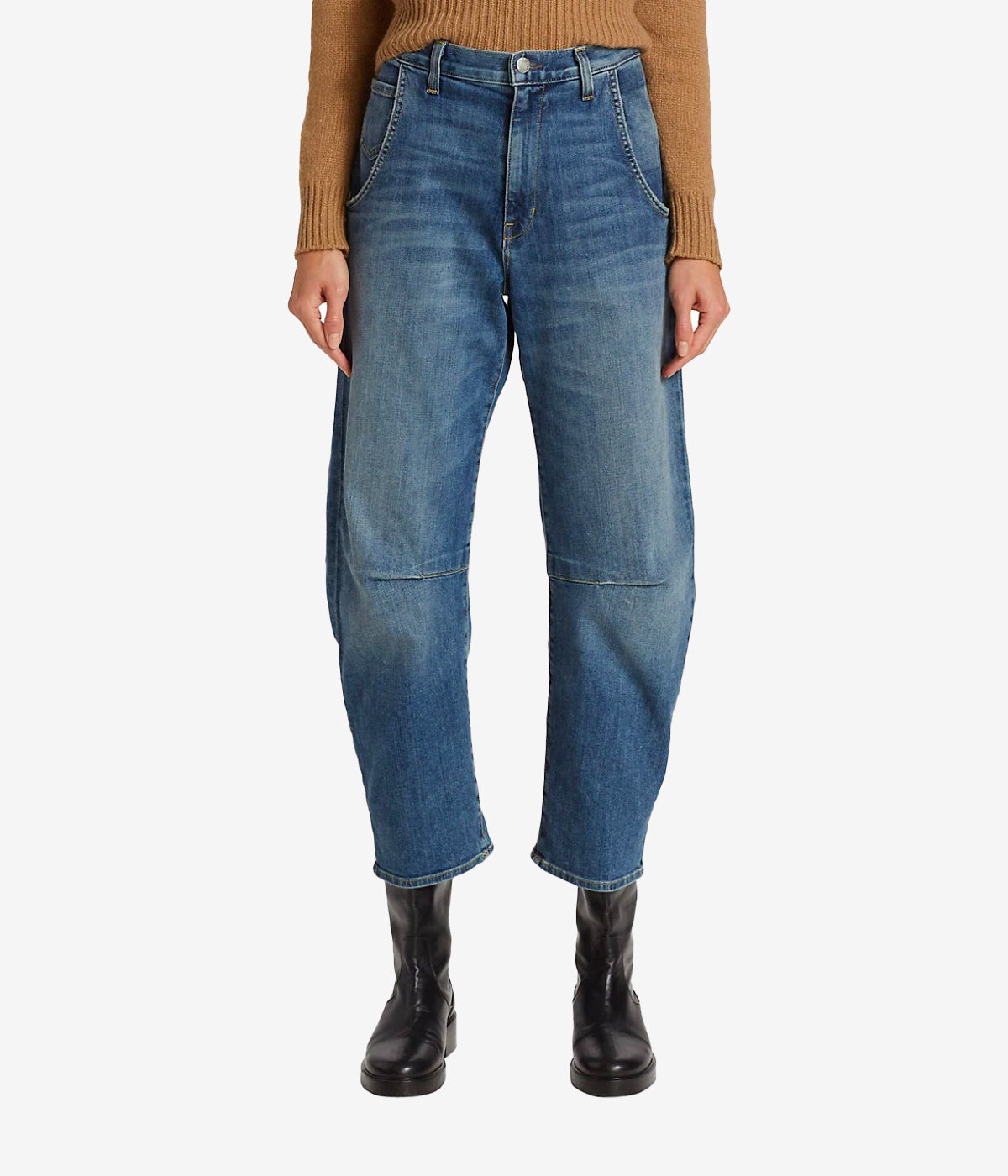 ALT text for images: Barrel silhouette jeans in faded blue denim, with tapered hems and utilitarian pockets, styled for a casual chic look.